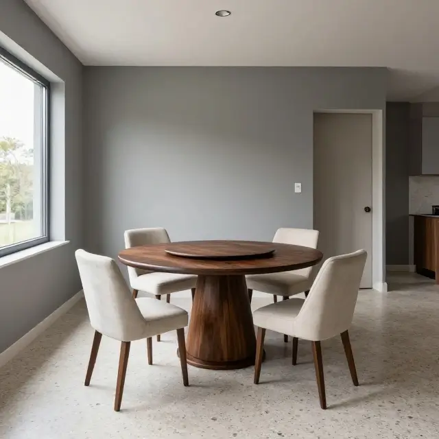 Compact modern dining room with a round cherry-wood pedestal table and four ivory upholstered chairs